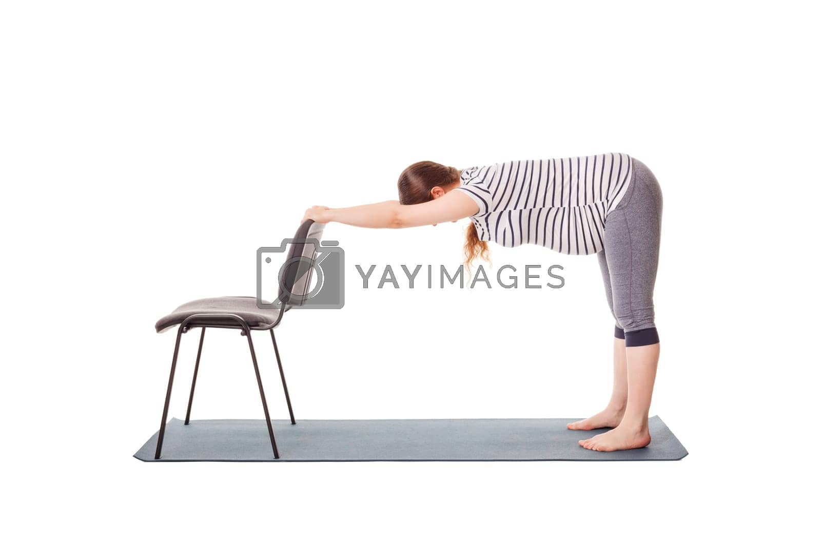 Royalty free image of Pregnant woman doing yoga asana Uttanasana by dimol