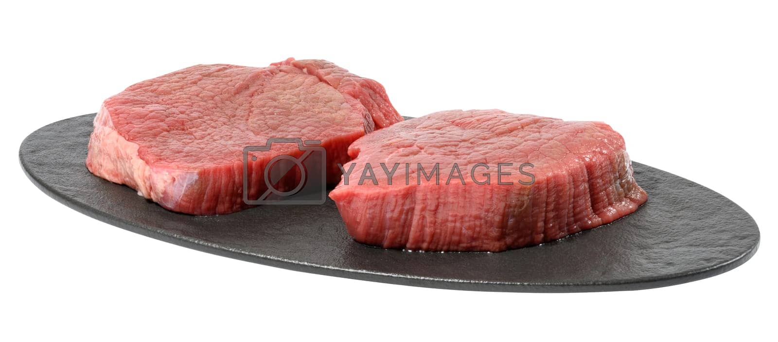 Royalty free image of Two round raw beef steak on a black oval cutting board, white isolated background by ndanko