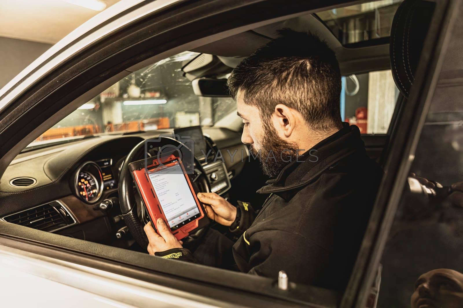 Royalty free image of Mechanic Running Diagnostics on Modern Car Computer by pippocarlot