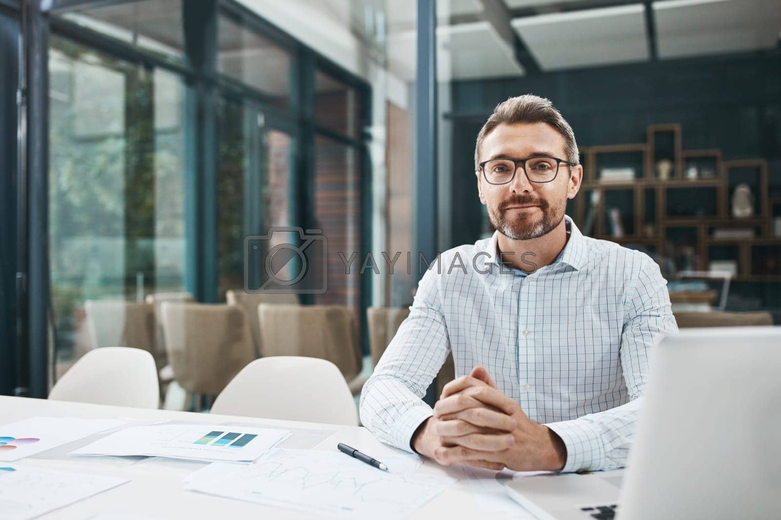 Royalty free image of He brings some much expertise to the fore. Portrait of a mature businessman working in an office. by YuriArcurs