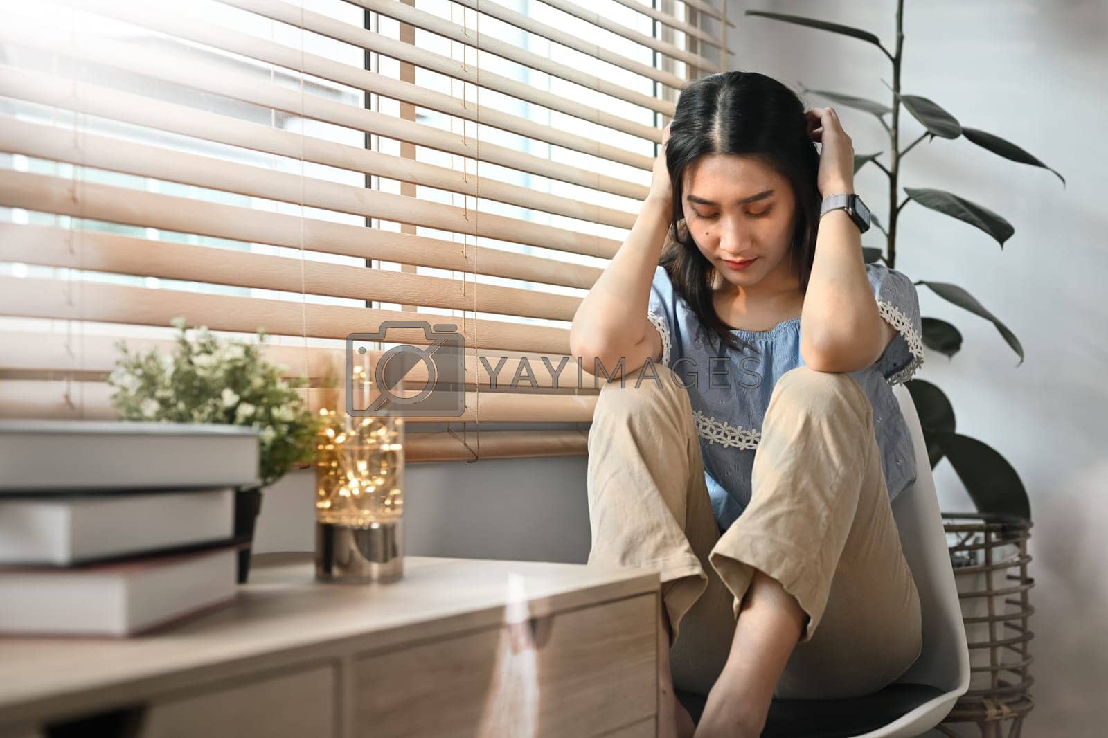 Royalty free image of Unhappy young woman holding her head, suffering from depression. Loneliness, depression, mental heath concept by prathanchorruangsak