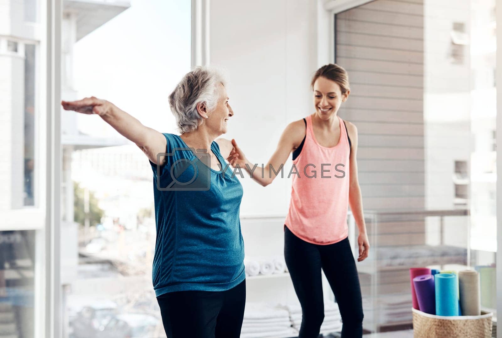 Royalty free image of Physical fitness is an important part of a healthy lifestyle. a fitness instructor helping a senior woman during a yoga class. by YuriArcurs