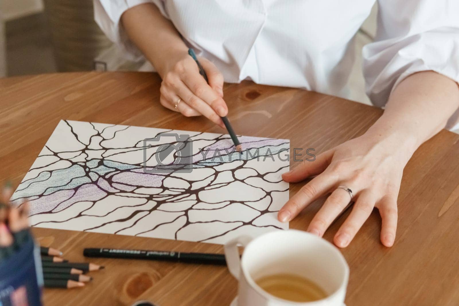 Royalty free image of TVER, RUSSIA - FEBRUARY 25, 2023: Woman draws neurographics at table at a psychological session, neurographic pencil drawing to remove restrictions, art therapy by Annu1tochka