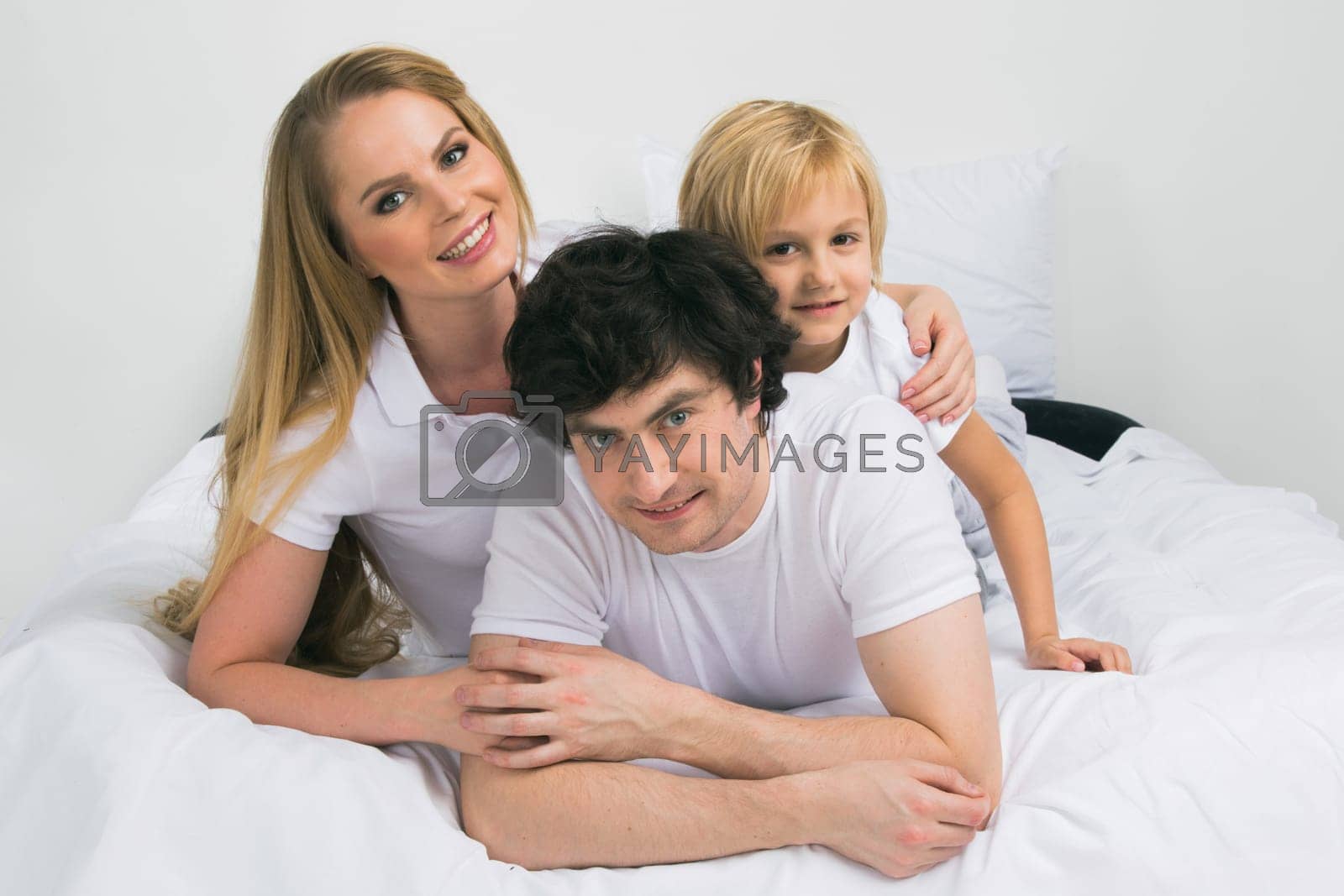 Royalty free image of Smiling family in bed by Yellowj