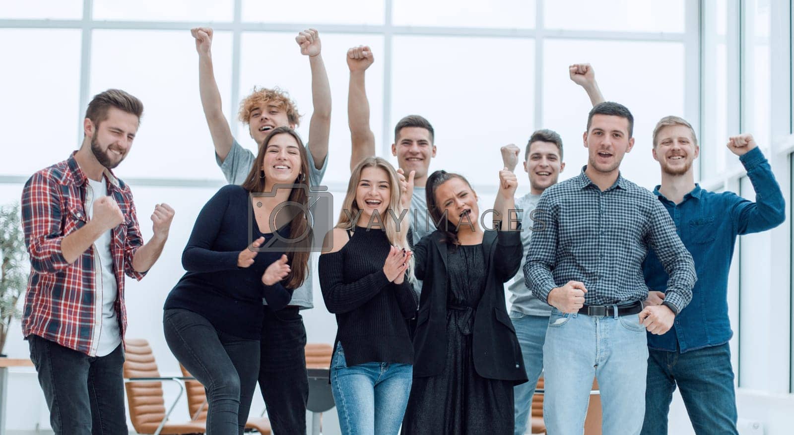 Royalty free image of team of happy young people standing in a new office by asdf