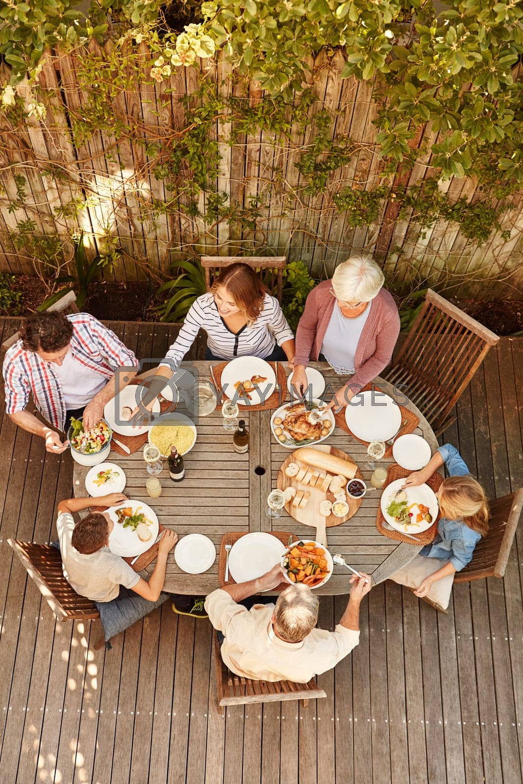 Royalty free image of Reconnecting as a family over lunch. High angle shot of a family eating lunch outdoors. by YuriArcurs