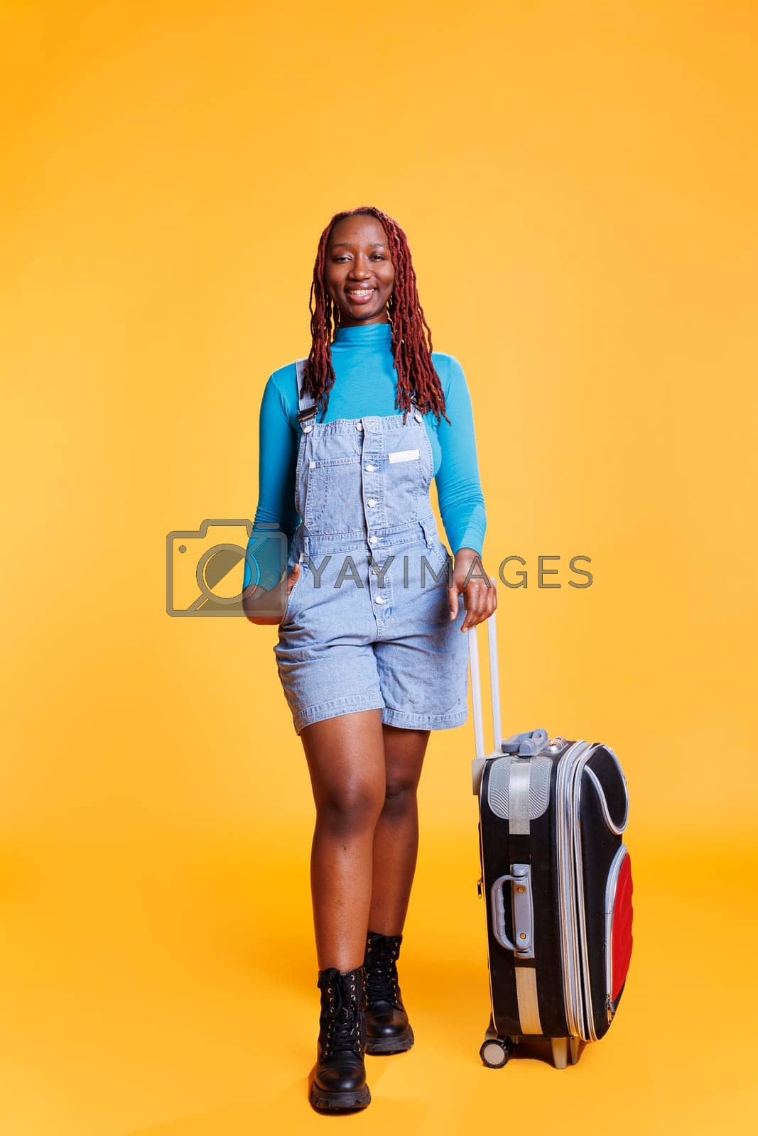 Royalty free image of Young traveller posing with trolley by DCStudio