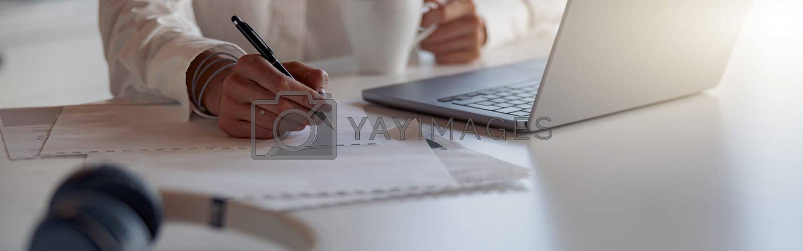 Royalty free image of Close up of business woman working laptop and making notes while sitting in modern office by Yaroslav_astakhov