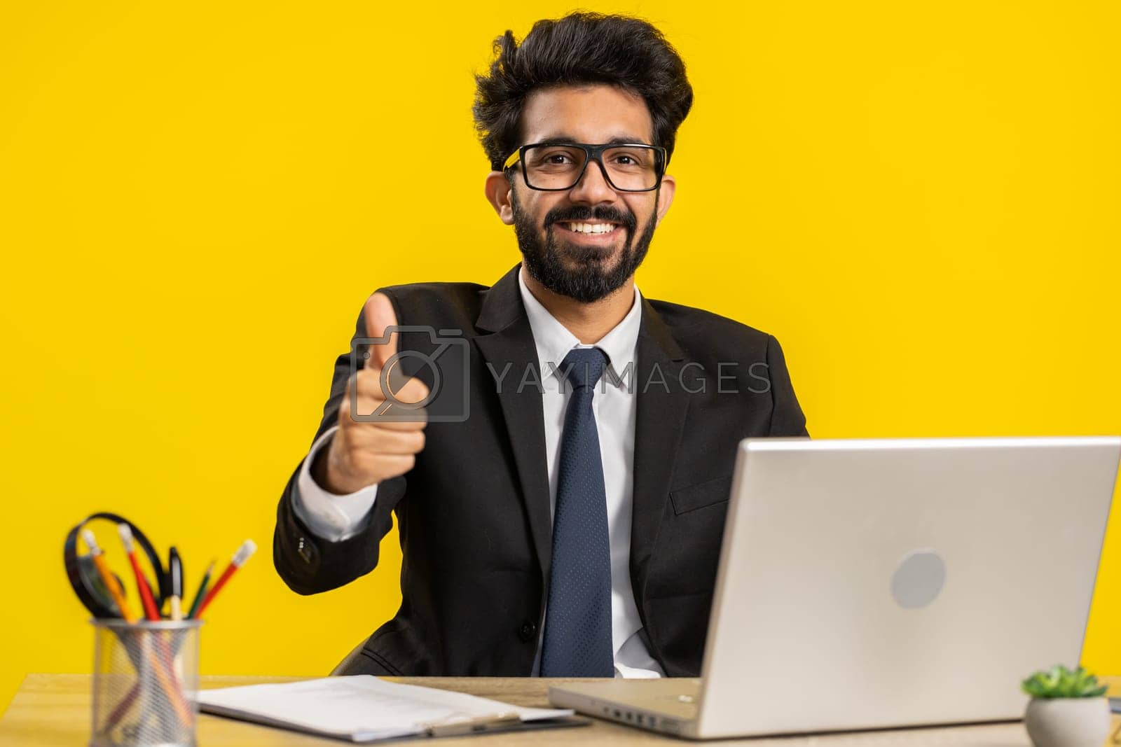 Royalty free image of Happy business man looking approvingly at camera showing thumbs up, like positive sign, good news by efuror