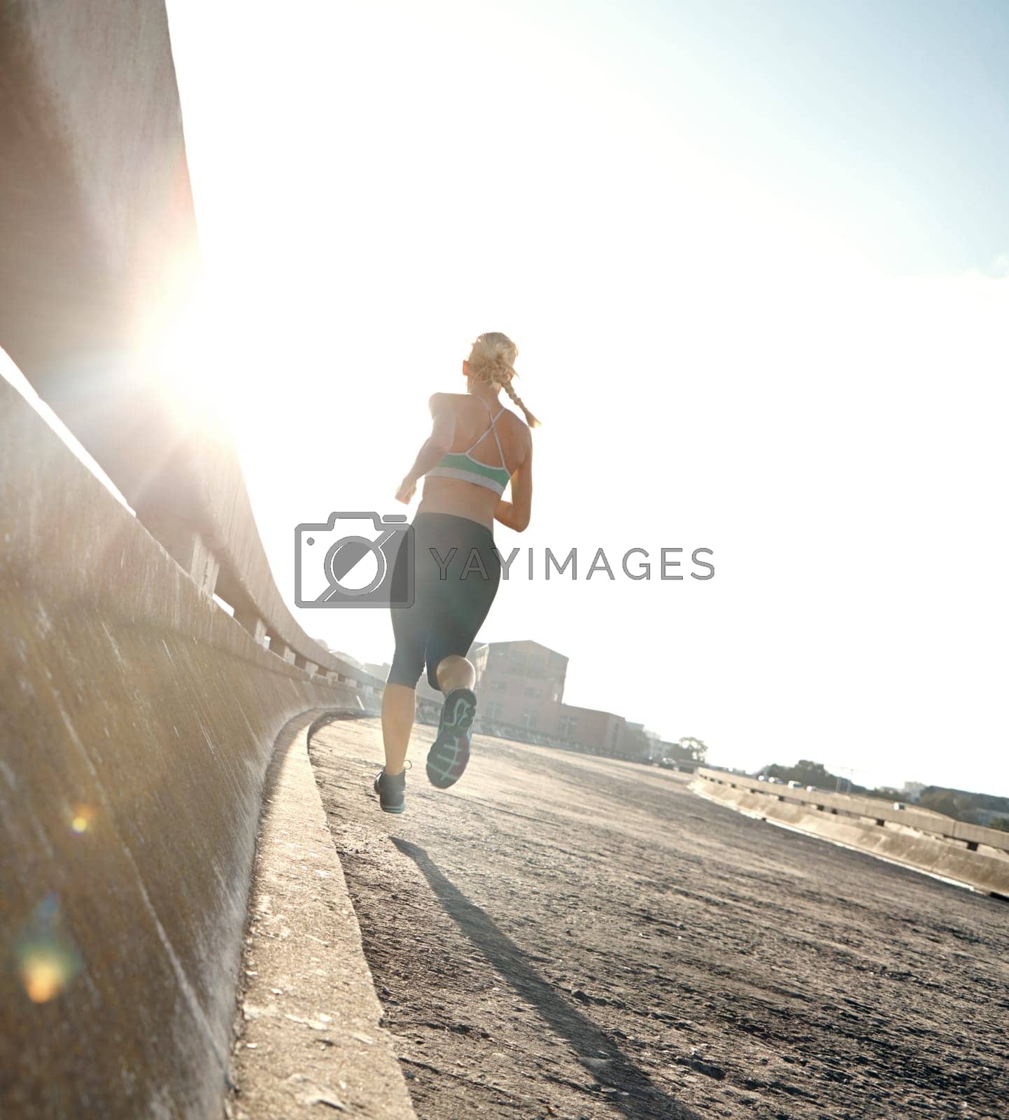 Royalty free image of Theres always further to go. Rear view shot of a young woman on her morning run. by YuriArcurs