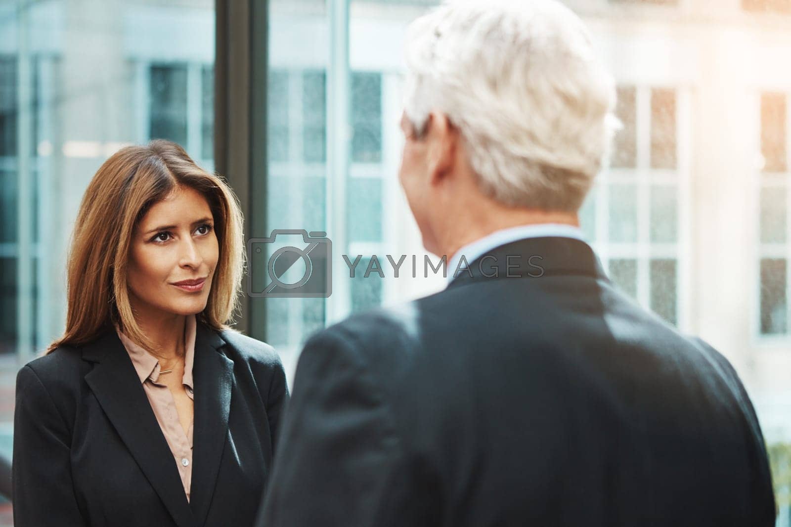 Royalty free image of Working closely with the head of operations. a businessman and businesswoman having a discussion in a modern office. by YuriArcurs