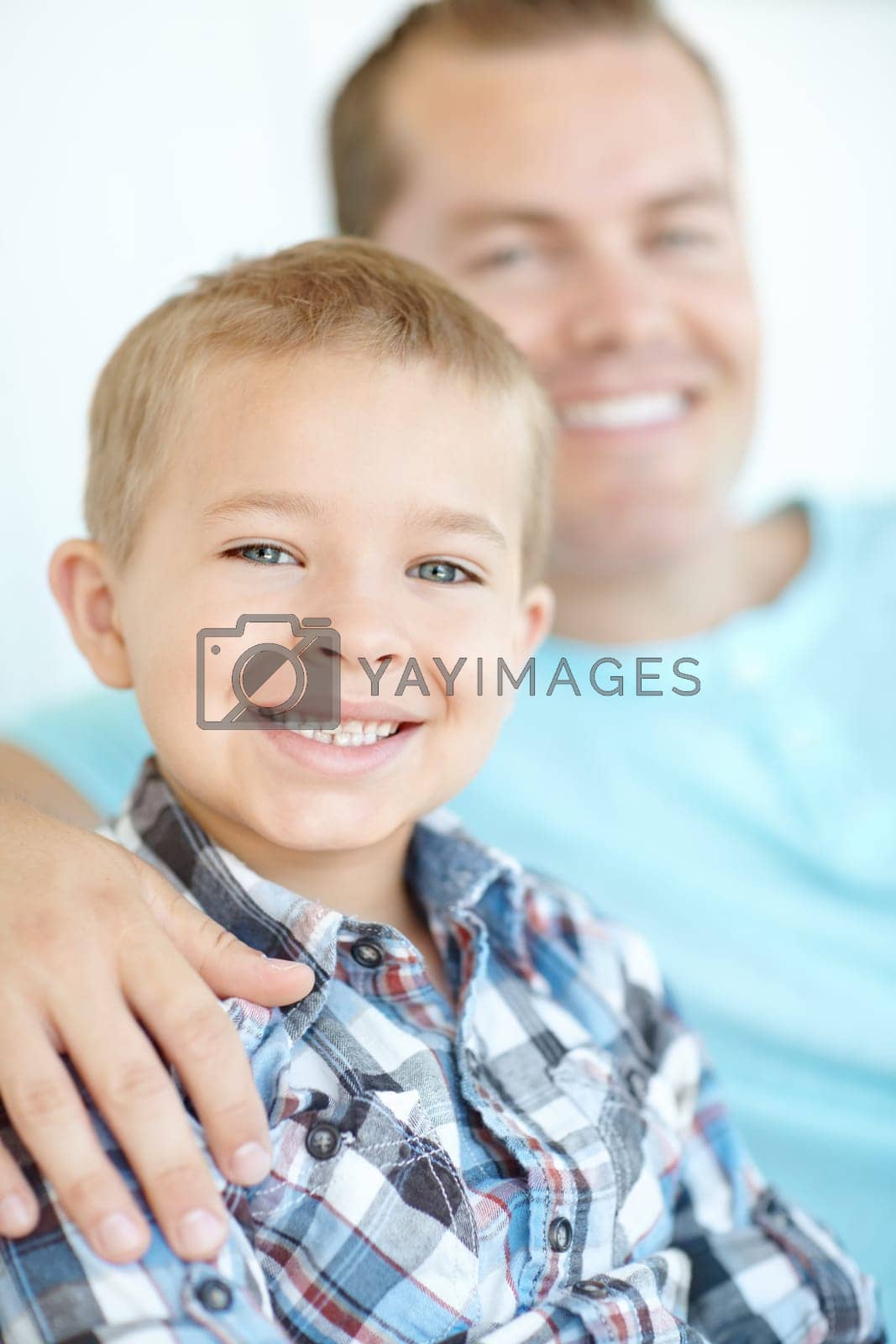 Royalty free image of Hes my best friend. Cropped portrait of a cute young boy sitting together with his dad at home. by YuriArcurs