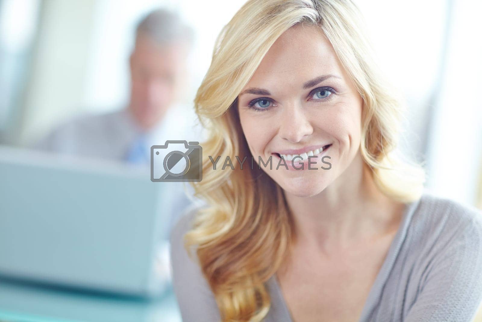 Royalty free image of Filled with the potential for success. Cropped portrait of an attractive blonde businesswoman with a coworker in the background. by YuriArcurs