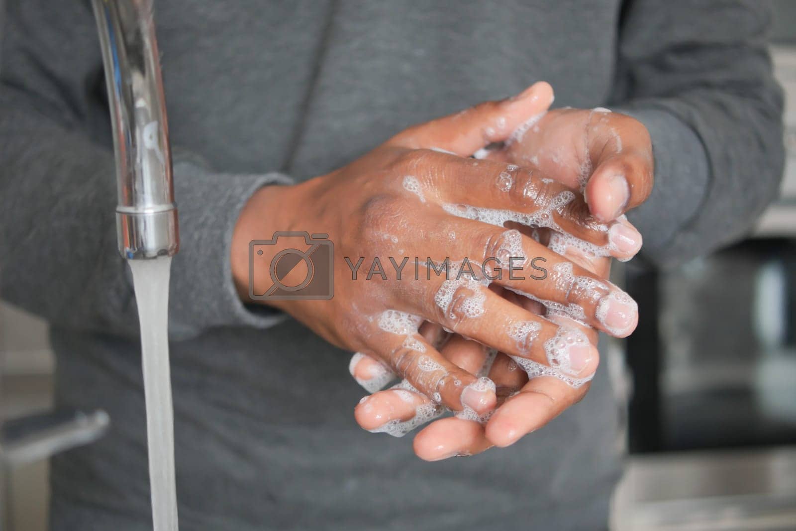 Royalty free image of young man washing hands with soap warm water by towfiq007
