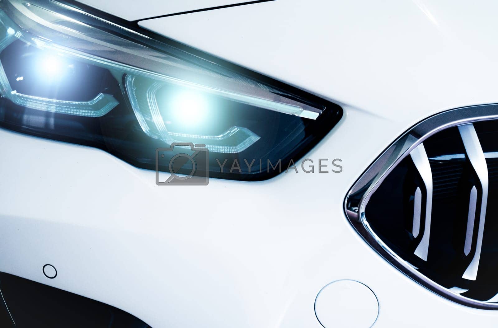Royalty free image of Closeup headlamp light of a white luxury car. Automotive industry concept. Electric car or hybrid vehicle concept. Automobile leasing and insurance concept. Auto leasing business. Electric vehicle. by Fahroni