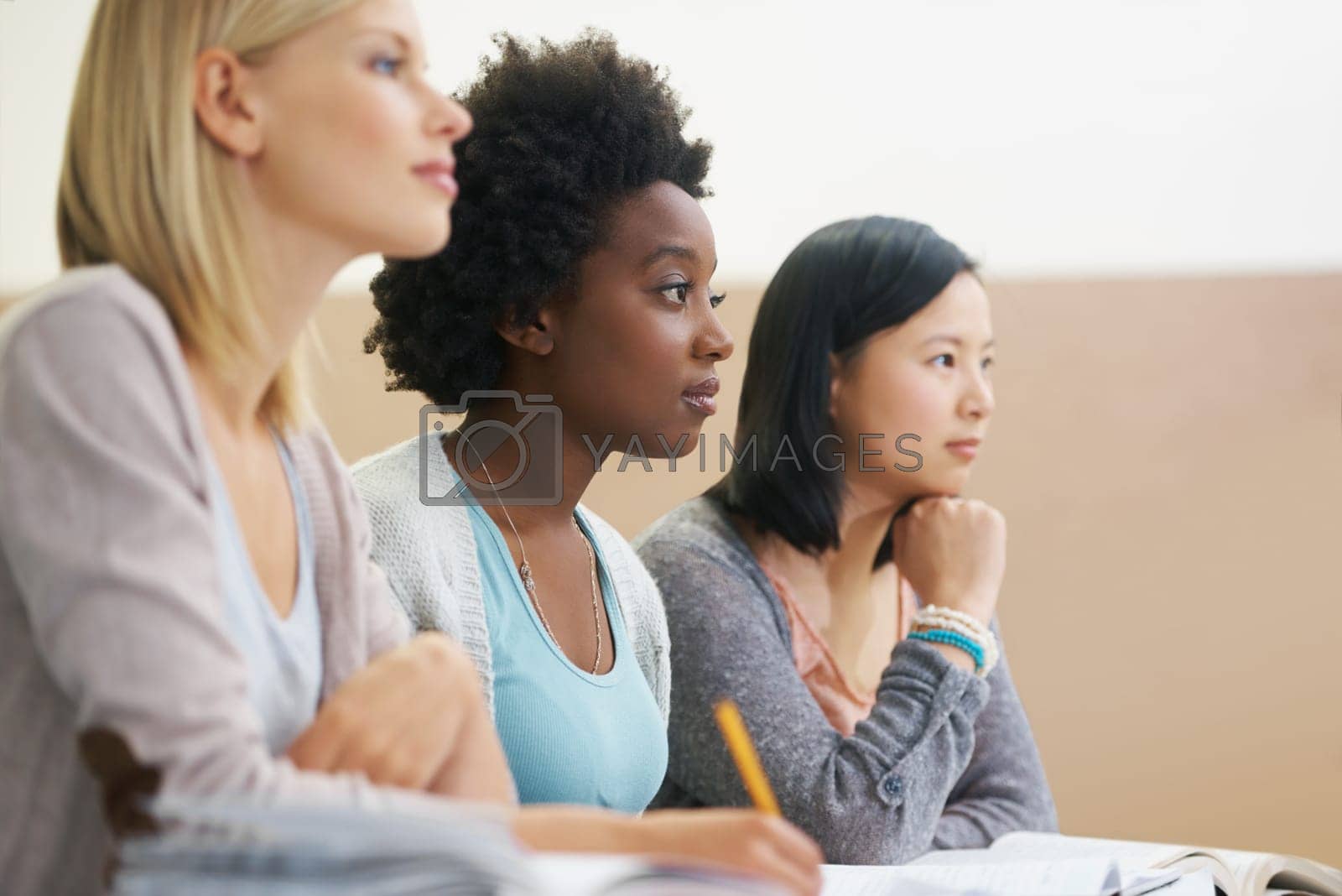 Royalty free image of Class is in session. female university students sitting in an exam room. by YuriArcurs