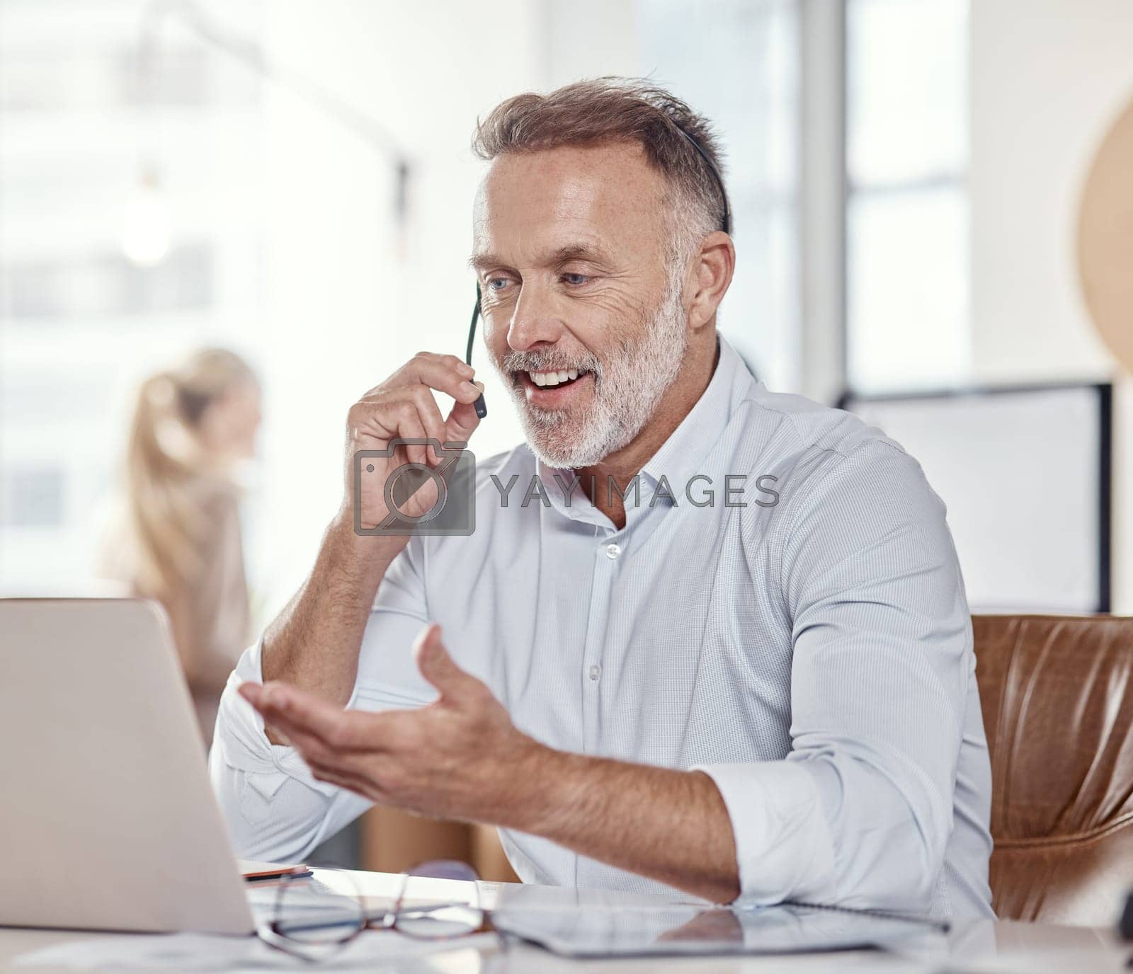 Royalty free image of All the experience youd want from a support professional. a mature man using a headset and laptop in a modern office. by YuriArcurs
