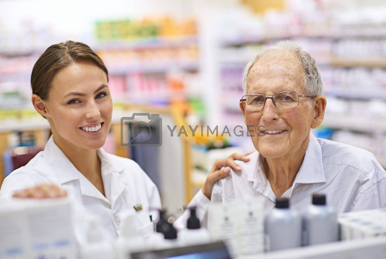 Royalty free image of Clients health is her foremost concern. Portrait of a young pharmacist helping an elderly customer. by YuriArcurs