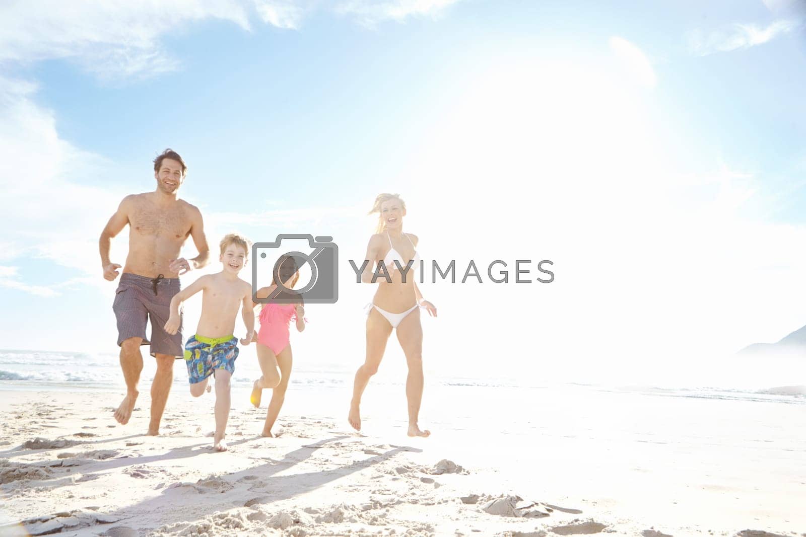 Royalty free image of For the love of Summer. a happy young family running on the beach together. by YuriArcurs