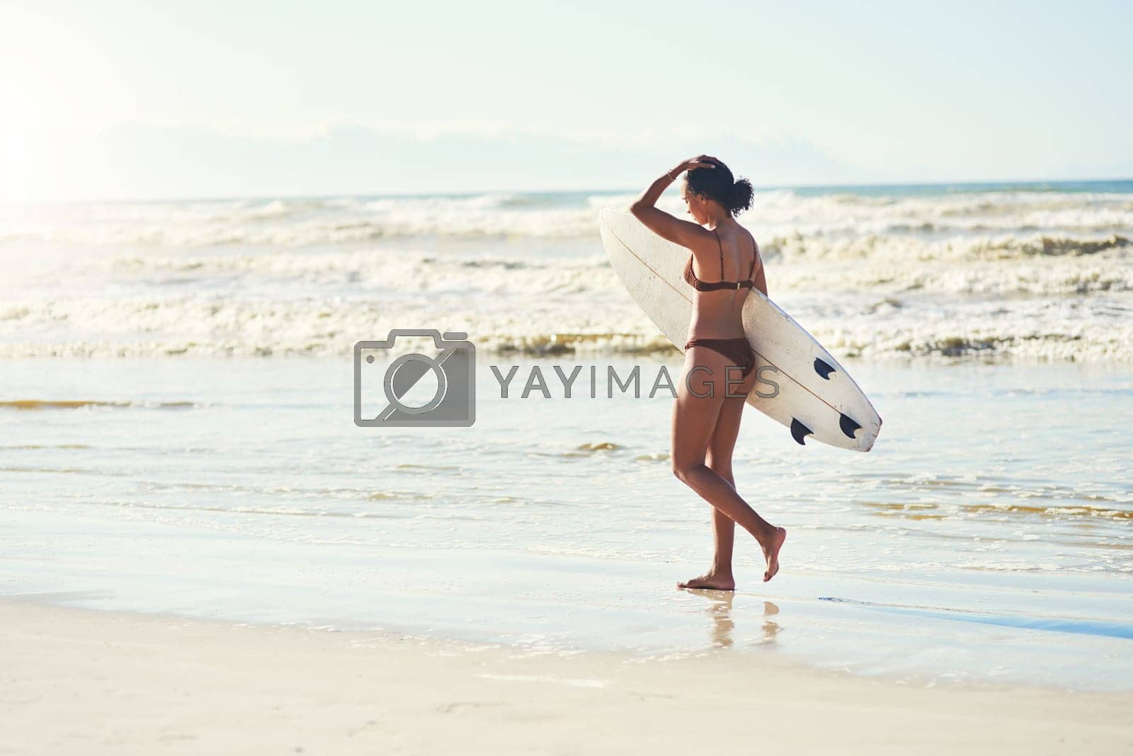 Royalty free image of I only enjoy surfing on days ending with y. a young woman out at the beach with her surfboard. by YuriArcurs