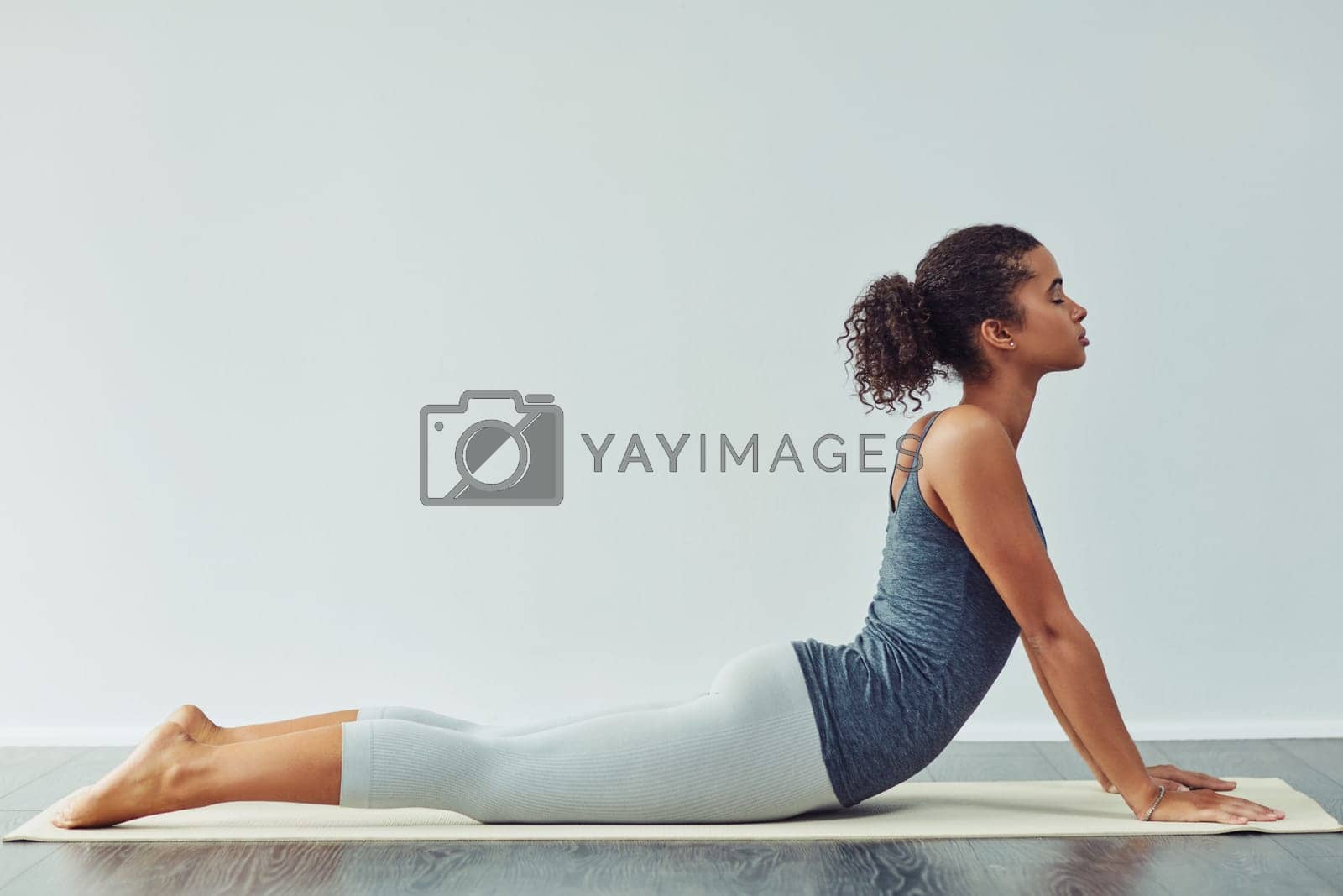 Royalty free image of Yoga is a great way to stretch your body. Studio shot of an attractive young woman practicing yoga against a grey background. by YuriArcurs