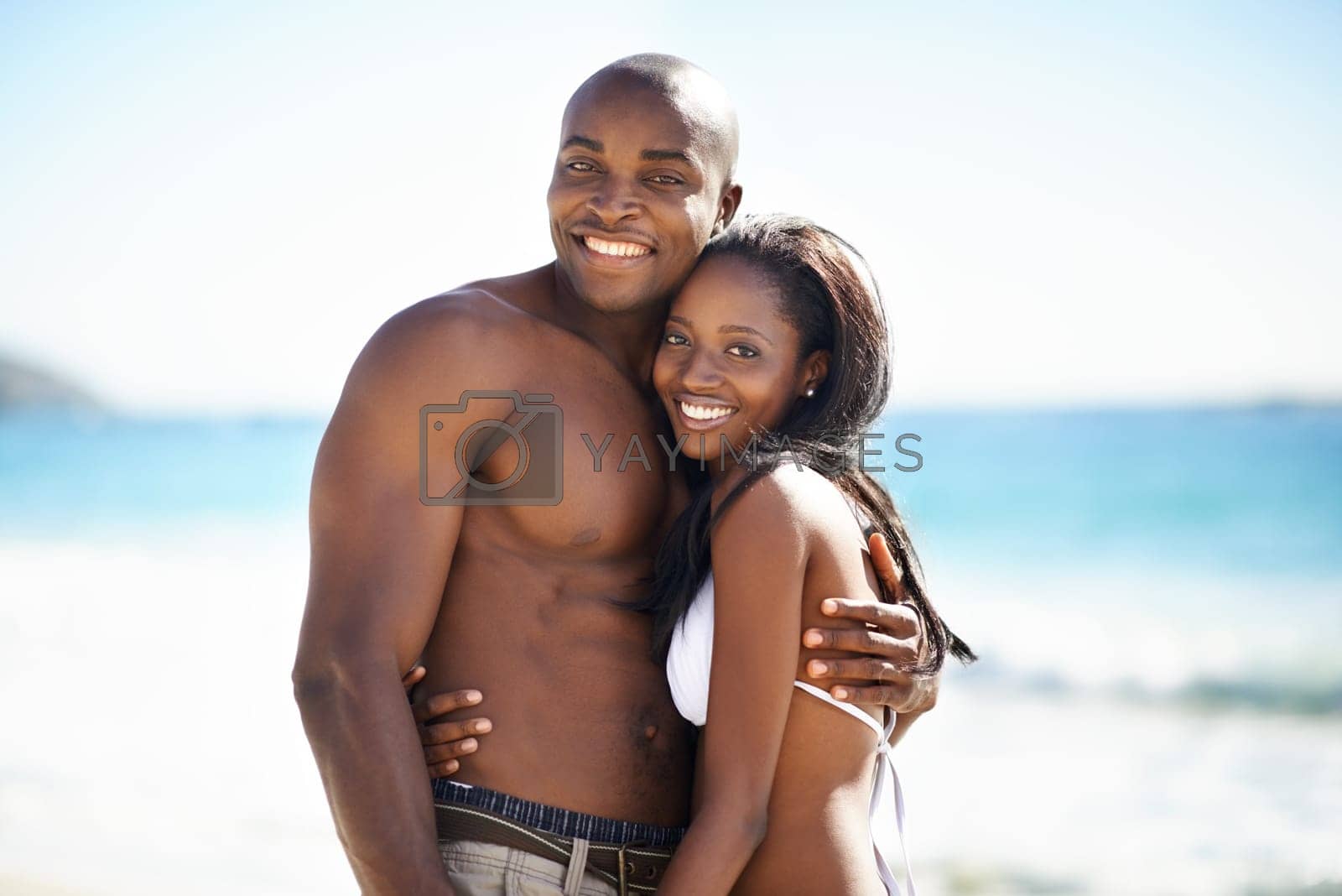 Royalty free image of Taking some time out to be with each other. A happy african-american couple embracing on the beach. by YuriArcurs