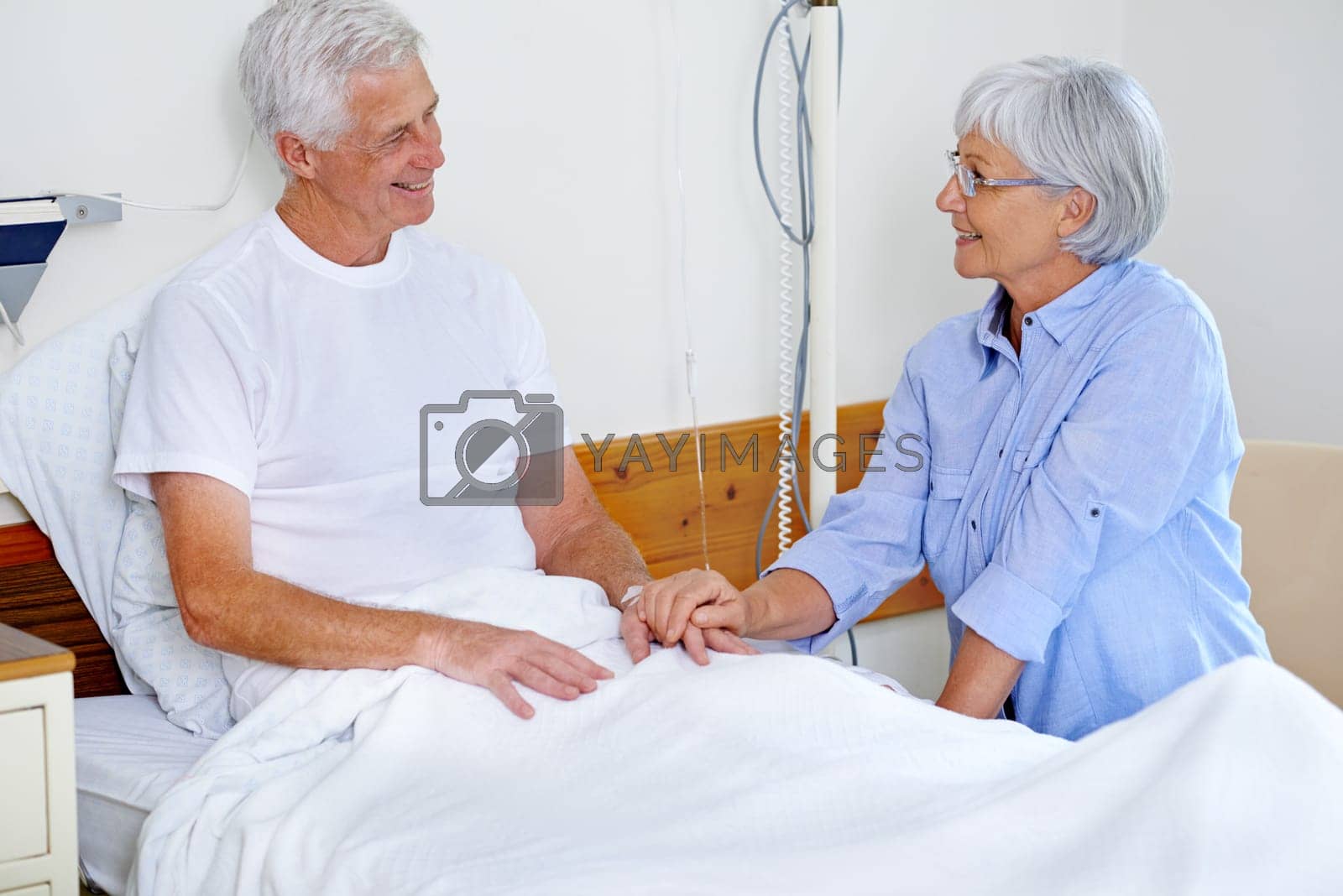 Royalty free image of For better or worse. a sick man in a hospital bed being comforted by his wife. by YuriArcurs