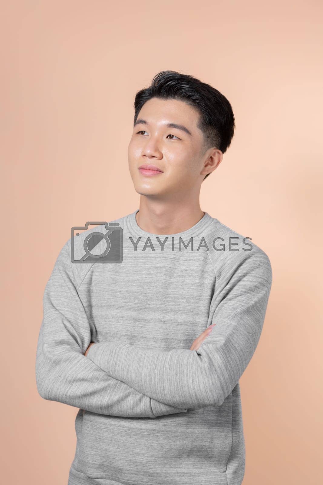 Royalty free image of Portrait of attractive cheerful experienced intelligent man folded arms isolated over beige background by makidotvn
