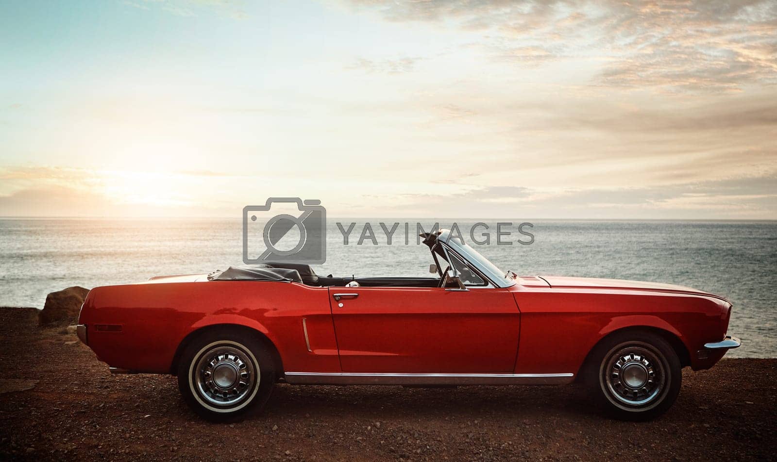 Royalty free image of Many memories were made in this car. an empty vintage car parked along the coast at sunset. by YuriArcurs