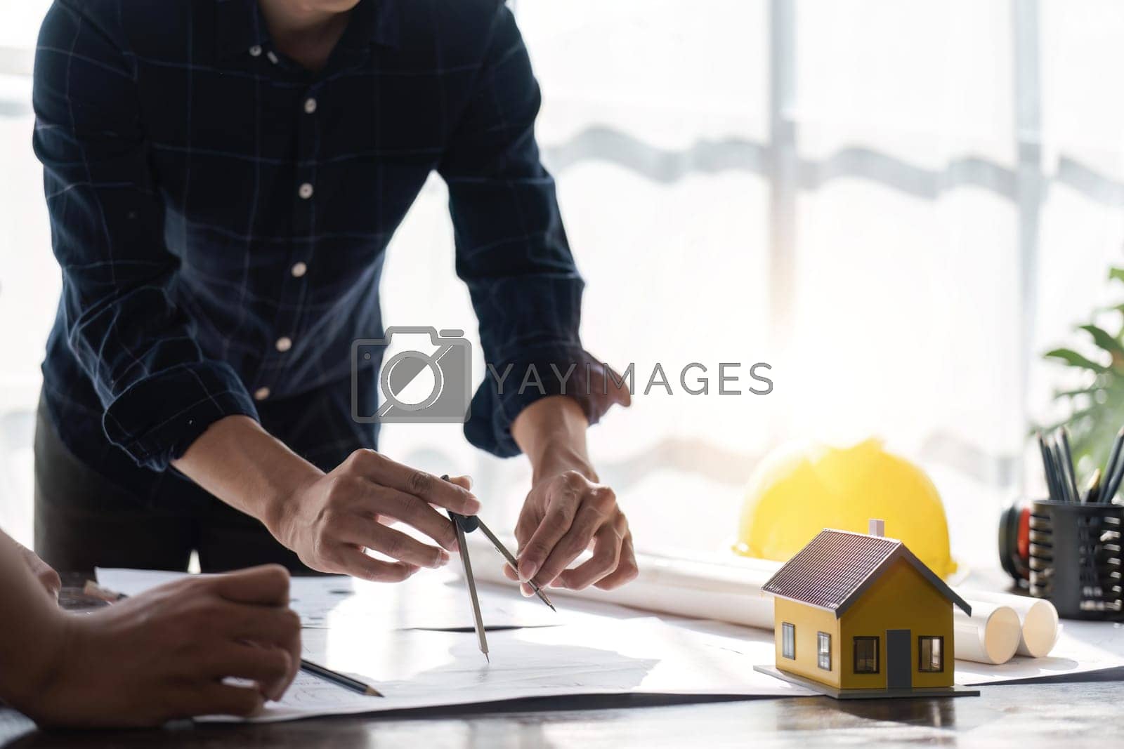 Royalty free image of engineer team planning design house, modifying plan, creating construction project and addition according to customer requirement by nateemee