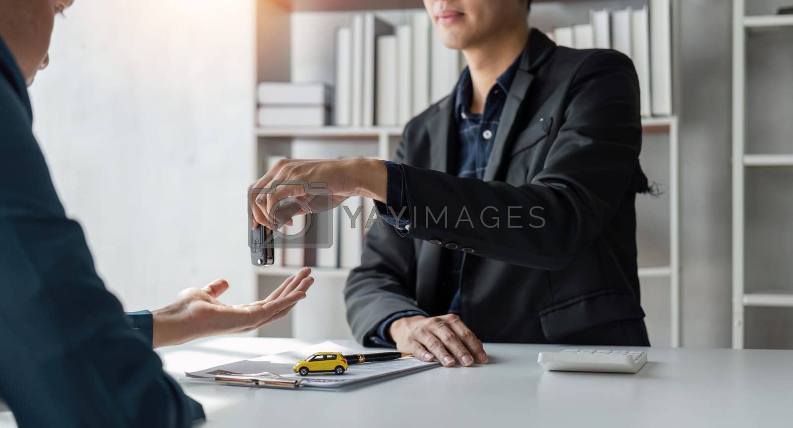 Royalty free image of Loan approver, businessman giving car keys after car loan approval and contract signing by nateemee
