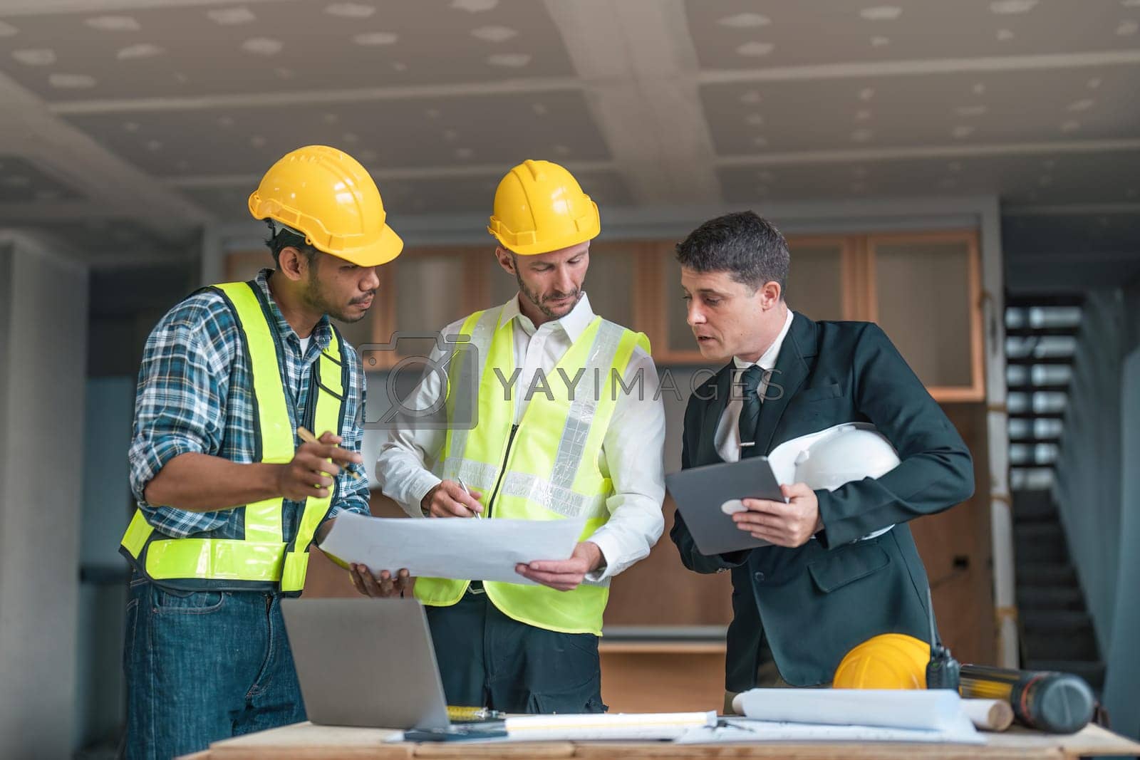 Royalty free image of Professional construction engineers team using blueprint of project plan brainstorming and working together at construction building, Architecture and building construction concept by nateemee