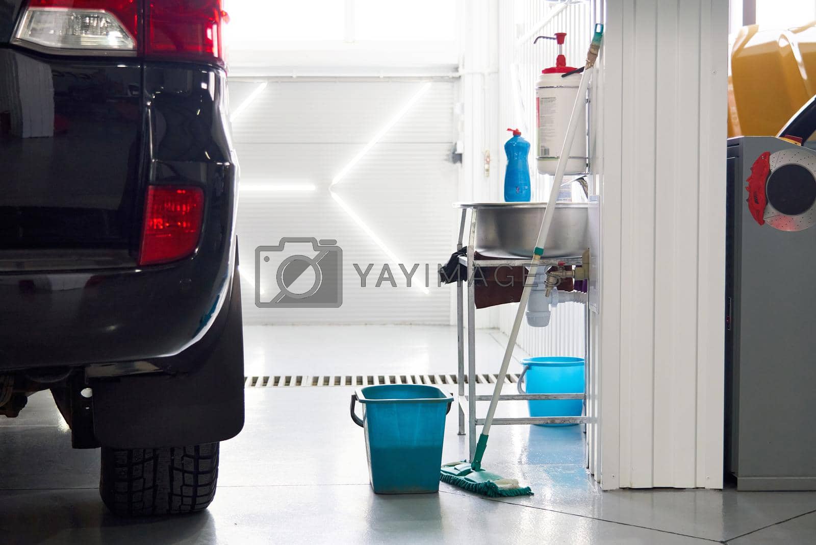 Royalty free image of cleaning floor in car workshop, keeping work place clean by Mariakray