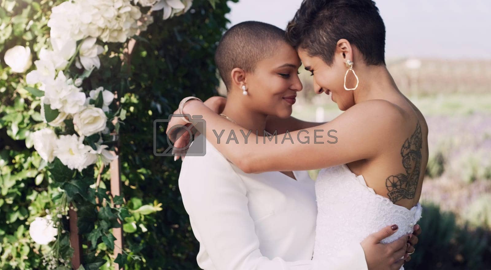 Royalty free image of love, hug and kiss with lesbian couple at wedding for celebration, gay and pride. Smile, spring and happiness with women at marriage event in garden for partner commitment, lgbtq and freedom by YuriArcurs