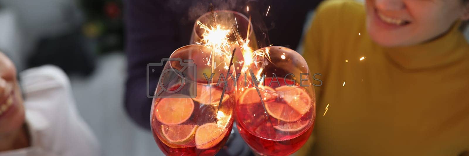 Royalty free image of Group of happy people enjoying fireworks party in cocktail glasses by kuprevich
