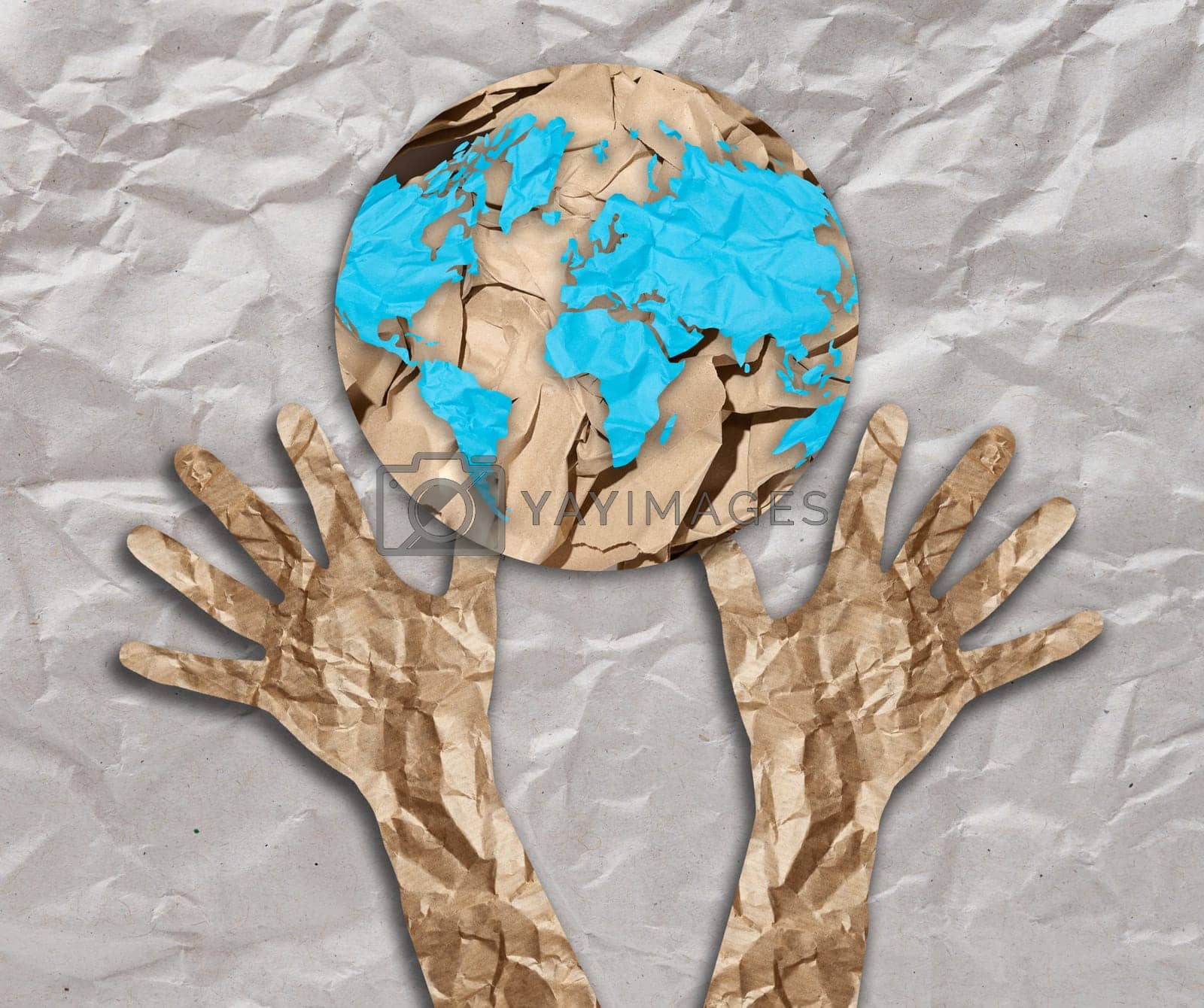 Royalty free image of Hands cut out of crumpled paper are raised to the shape of a globe. The concept of environmental conservation, ecology by ndanko
