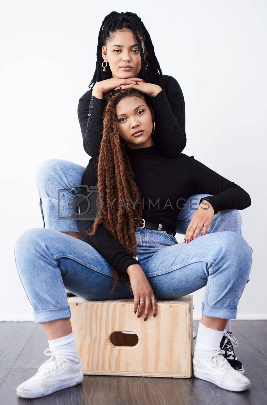 Royalty free image of They love being fashionable together. Studio shot of two beautiful young women posing against a grey background. by YuriArcurs