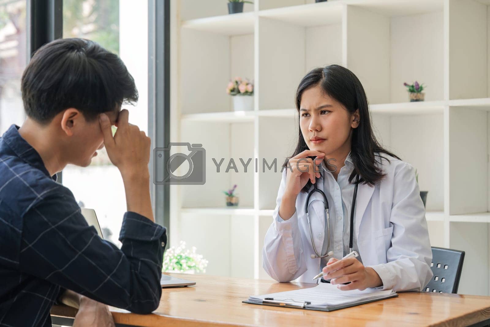 Royalty free image of Young asian woman doctor consulting asian worried patient patient on room in hospital, friendly female physician practitioner talking, giving recommendation, discussing checkup or symptoms by nateemee