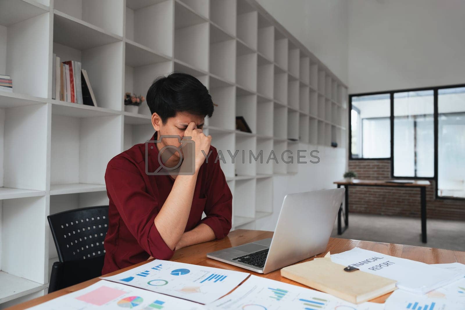 Royalty free image of Stress, anxiety and burnout with work a business man at work using a laptop while suffering from a headache by nateemee