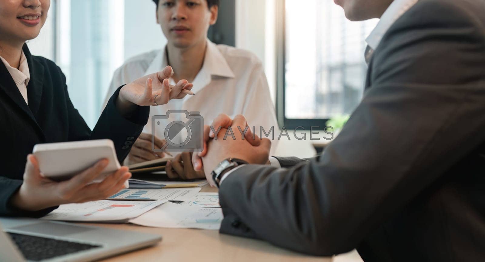 Royalty free image of Asian business adviser meeting to analyze and discuss the situation on the financial report in the meeting room. Investment Consultant, Financial Consultant, Financial advisor and accounting concept by nateemee