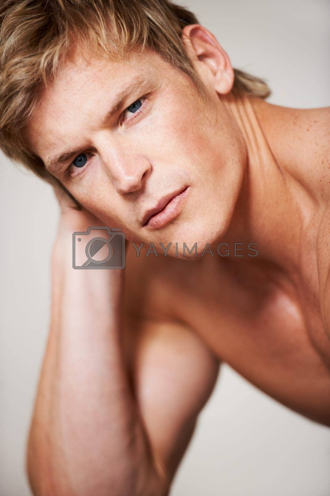 Royalty free image of Man, portrait and shirtless muscle in studio or white background for confident masculine, strong body or bodybuilder pride. Male person, model and face or topless or bicep arms, attractive or serious by YuriArcurs