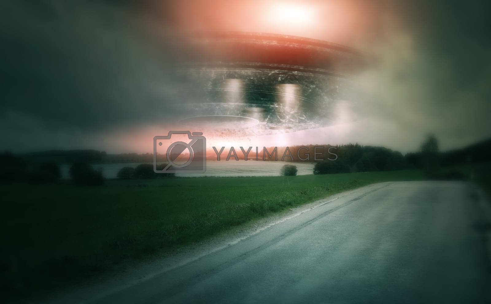Royalty free image of UFO, spaceship and countryside with alien in sky for fantasy or science fiction event in nature, field or landscape with clouds. Earth, aliens and extraterrestrial drone in environment with blur by YuriArcurs