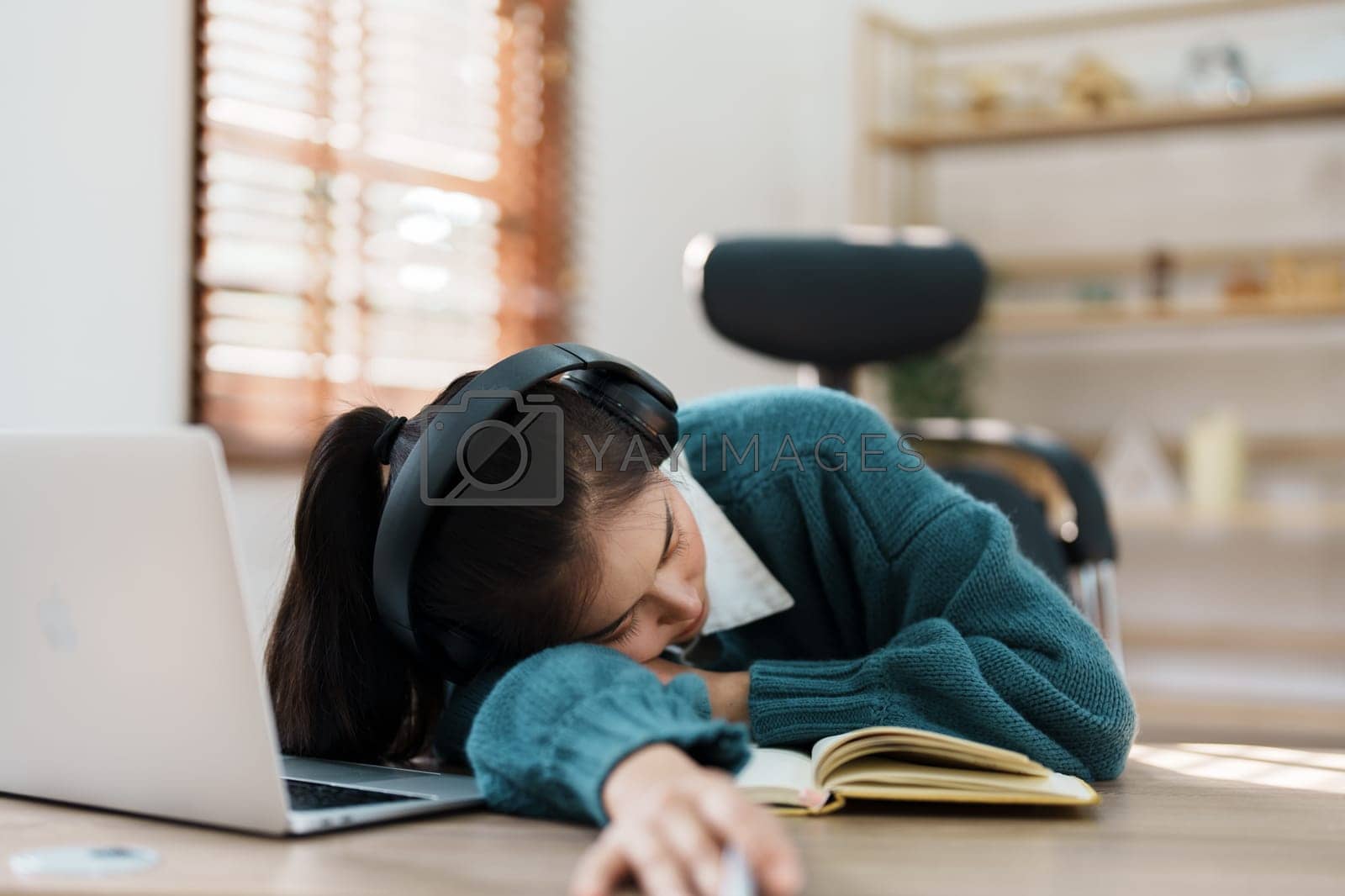 Royalty free image of Studying online, beautiful Asian female student show symptoms burnout syndrome student studying online at home by Manastrong