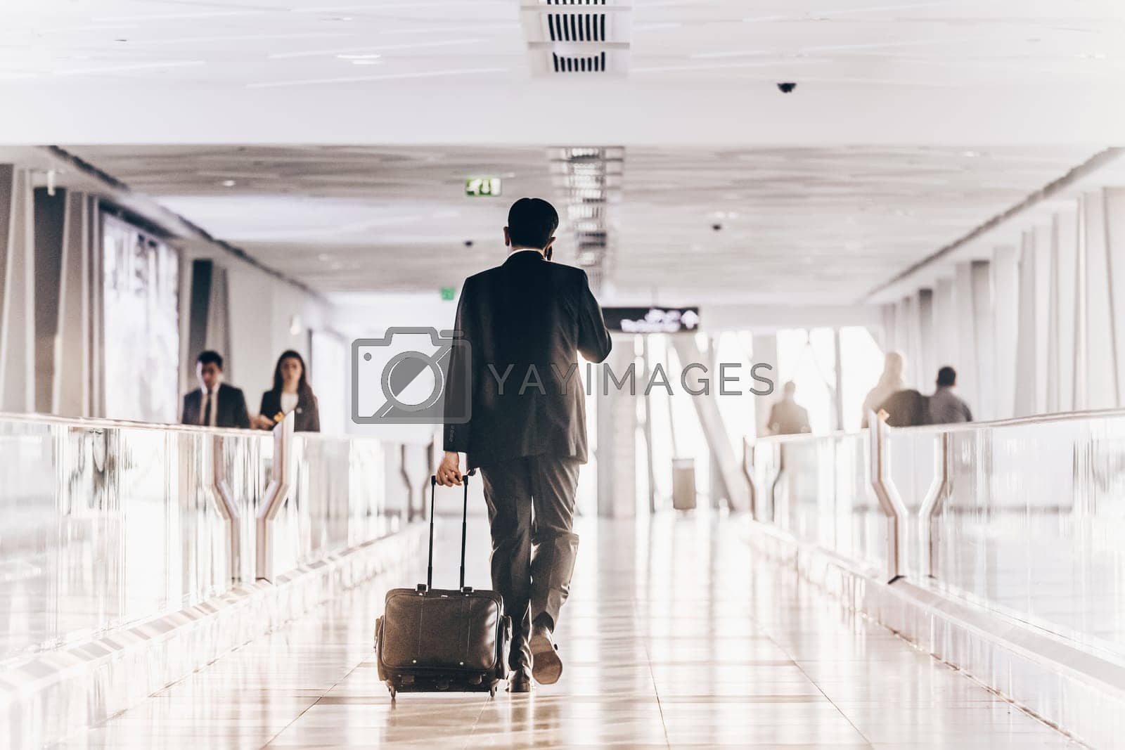 Royalty free image of Businessman at airport corridor walking to departure gates. by kasto