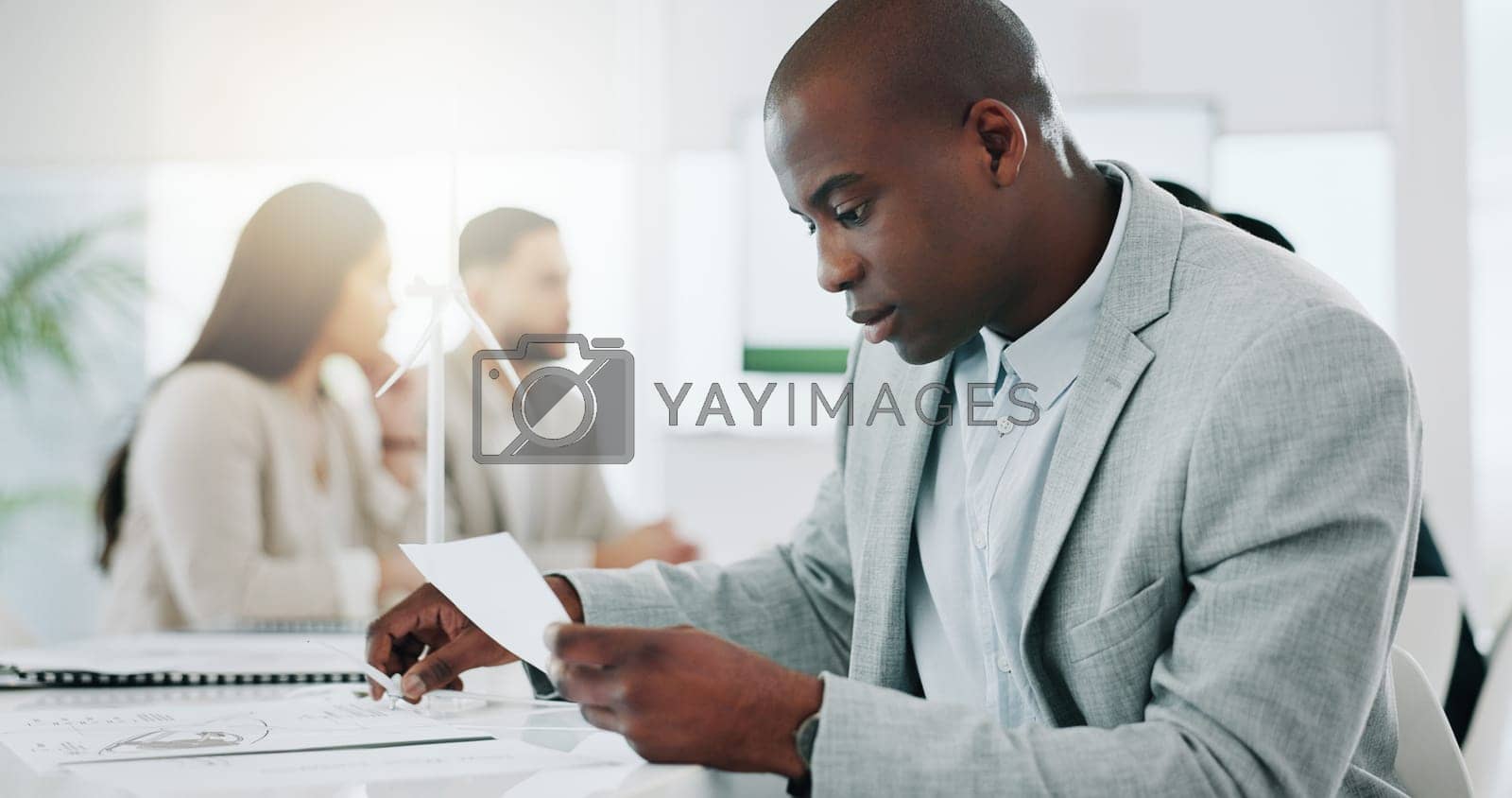 Royalty free image of Wind turbine, planning and black man in office working on clean energy and sustainability electricity. Engineering, construction project and architect with eco friendly and biodiversity design by YuriArcurs