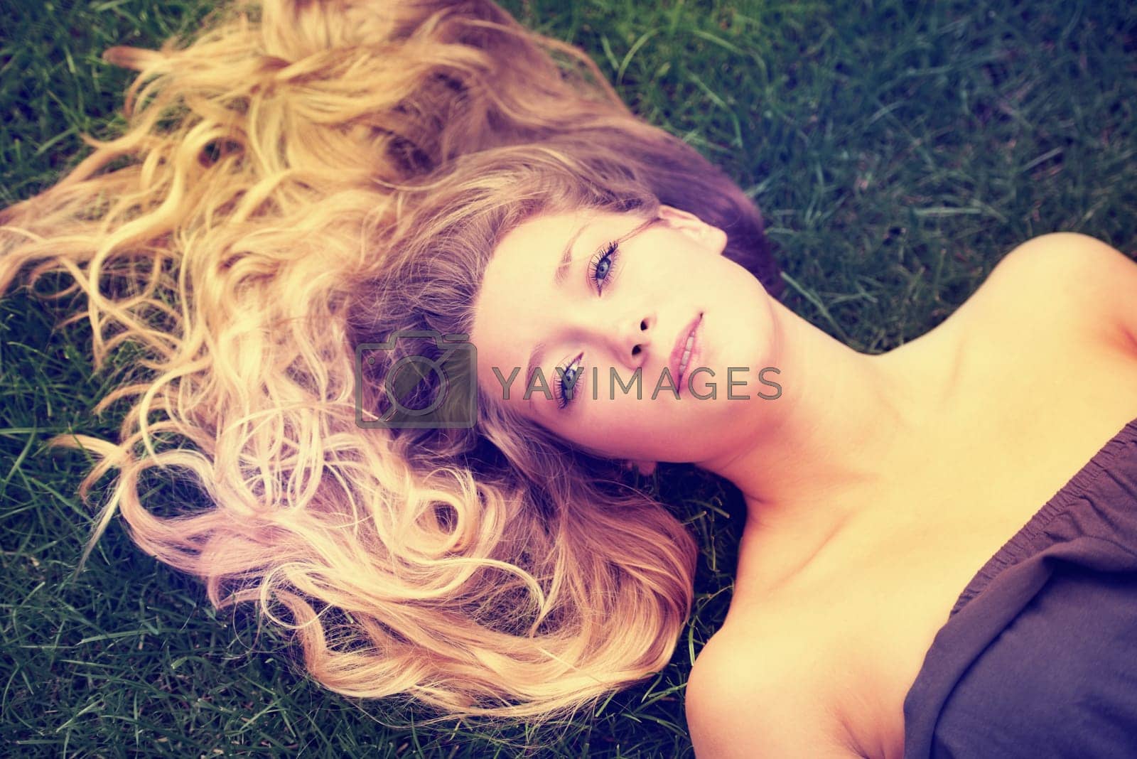 Royalty free image of Portrait, hair and a woman on the grass from above to relax in nature during summer for freedom. Face, beauty and a girl in the park, lying on a field outdoor to rest on a green background alone by YuriArcurs