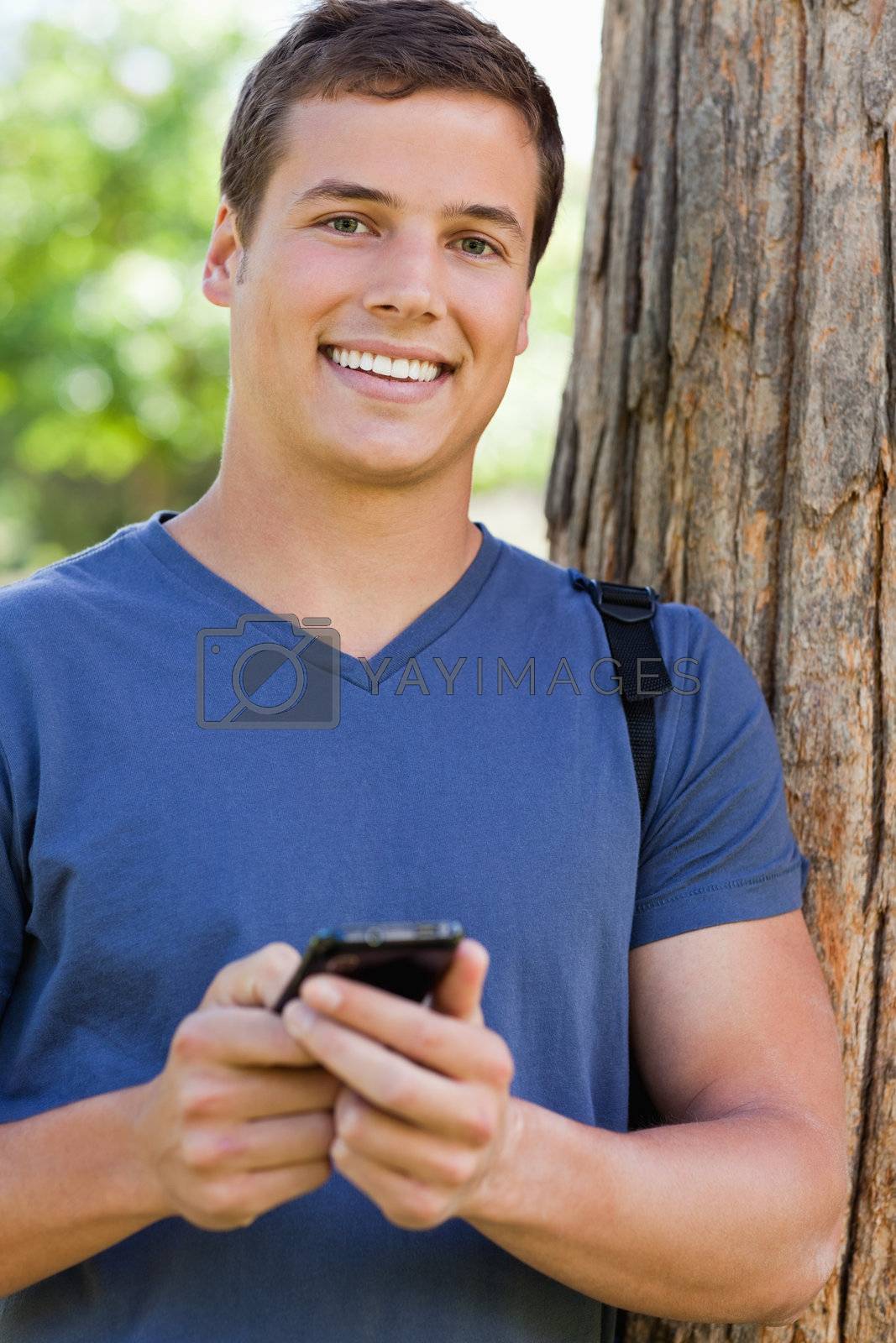 Royalty free image of Portrait of a muscled student with a smartphone by Wavebreakmedia