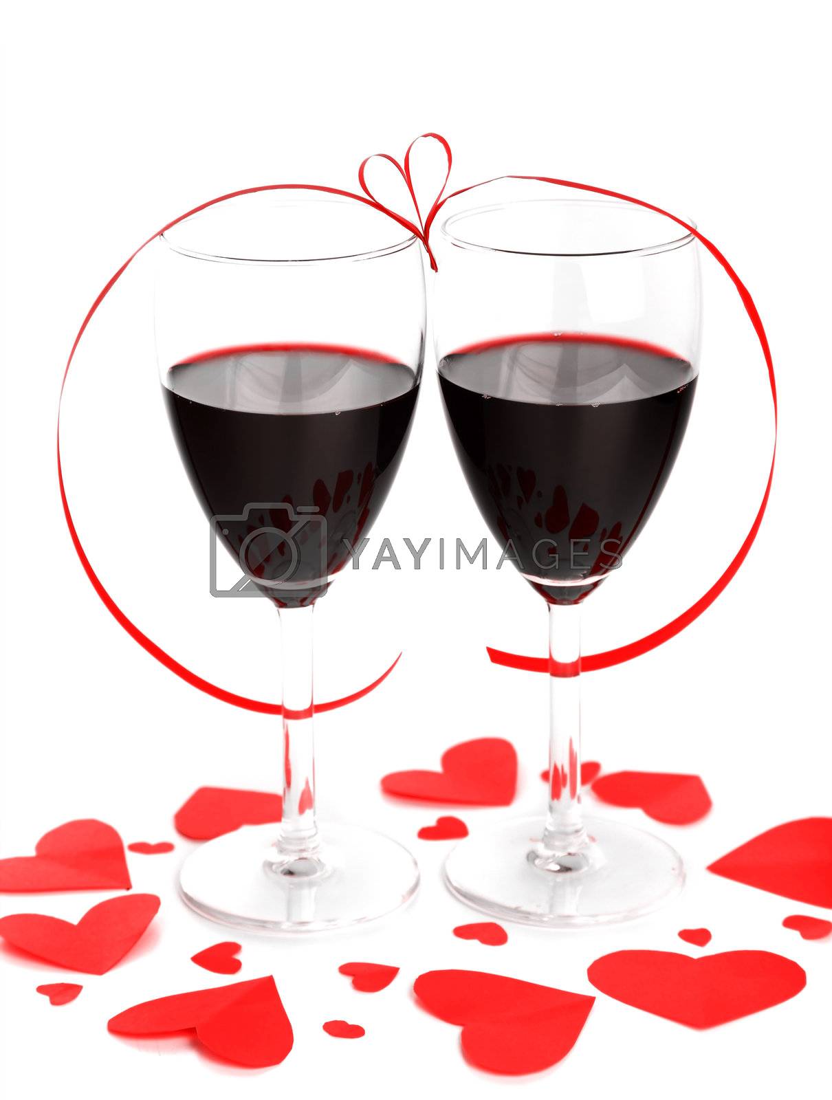 Romantic holiday drink, celebration of valentine's day, red wine with hearts ornament & ribbon decoration, isolated on white background