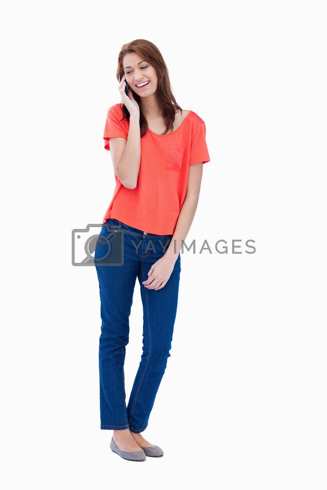 Royalty free image of Relaxed teenager smiling while talking on the phone by Wavebreakmedia