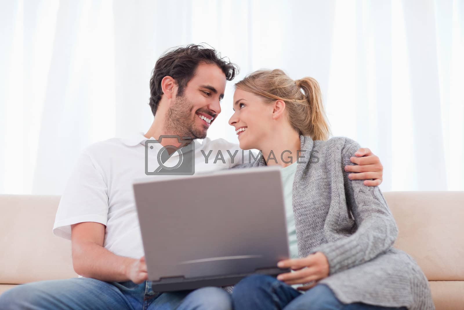 Royalty free image of Happy couple using a laptop by Wavebreakmedia